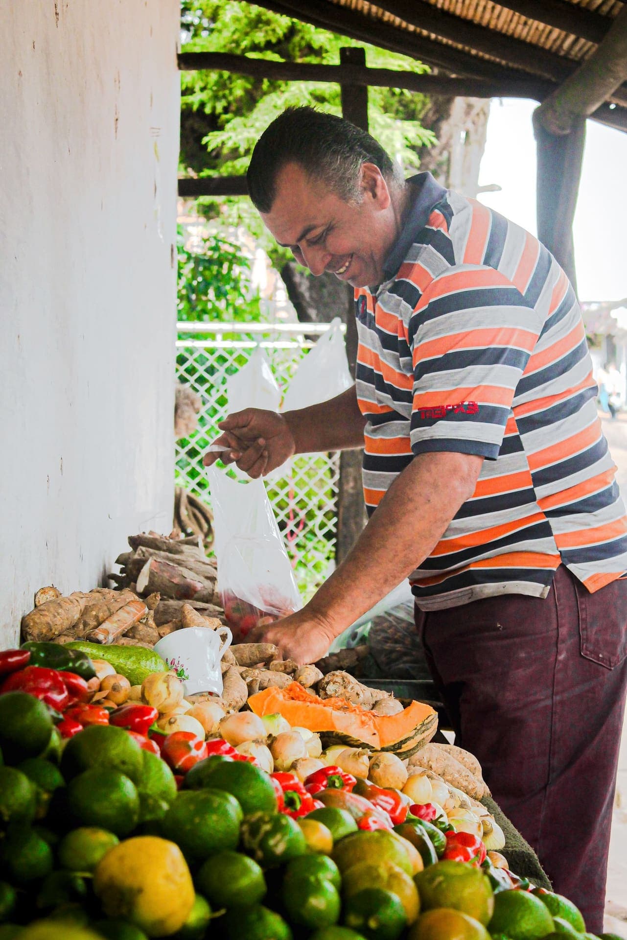 Vendedor despachando hortalizas en el puesto del mercado